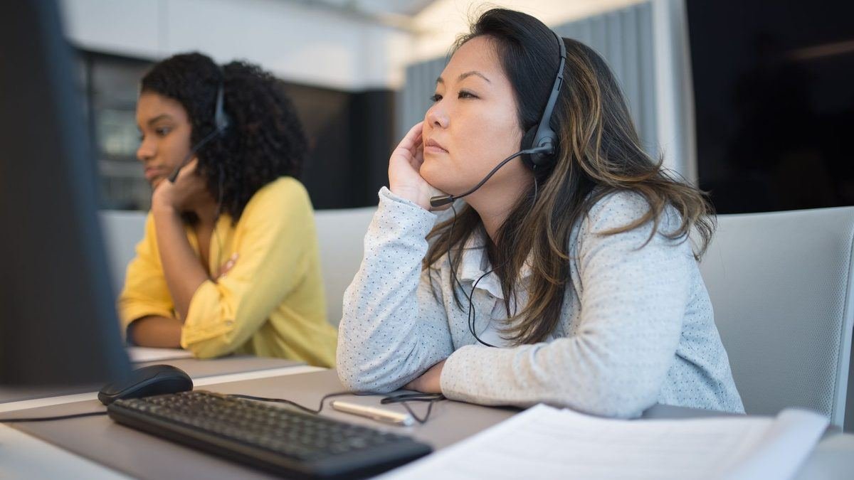 Two agents wearing headsets at a call centre desk