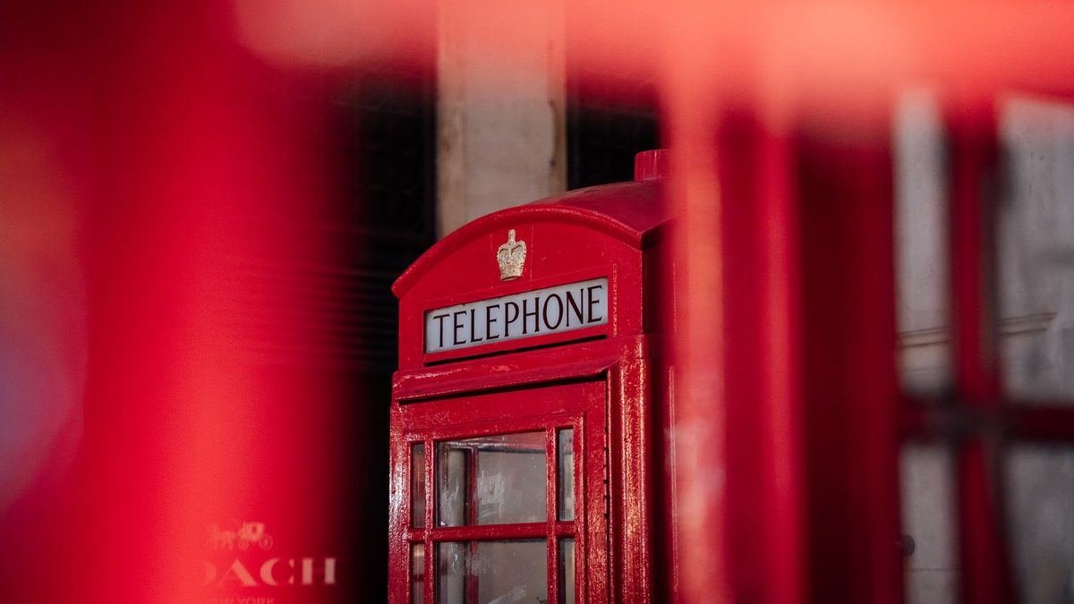 A classic British red telephone box on a London street